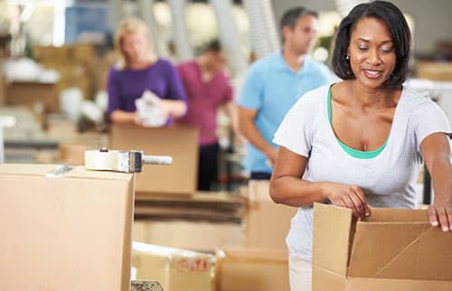 Employees packing boxes in warehouse